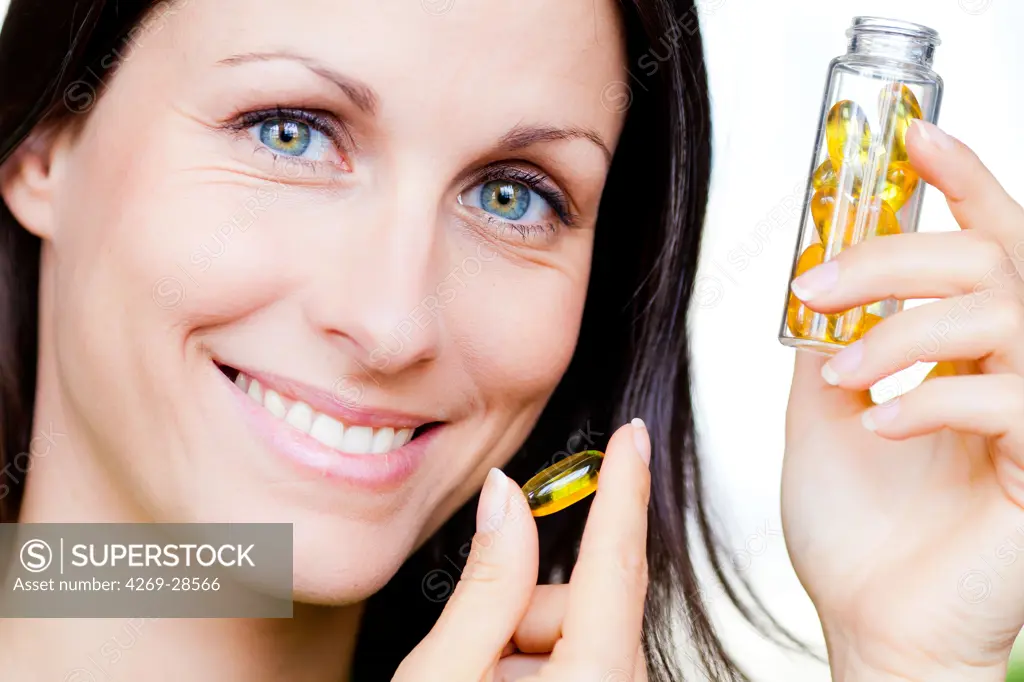 Woman taking food supplement capsules.