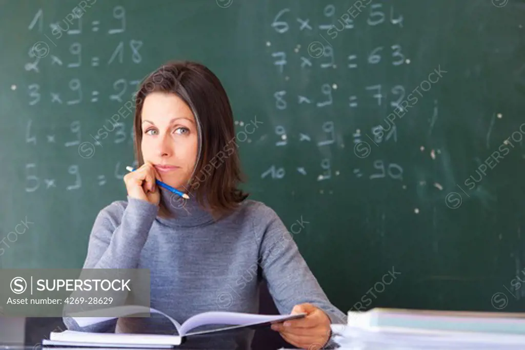 School teacher marking work at her desk.