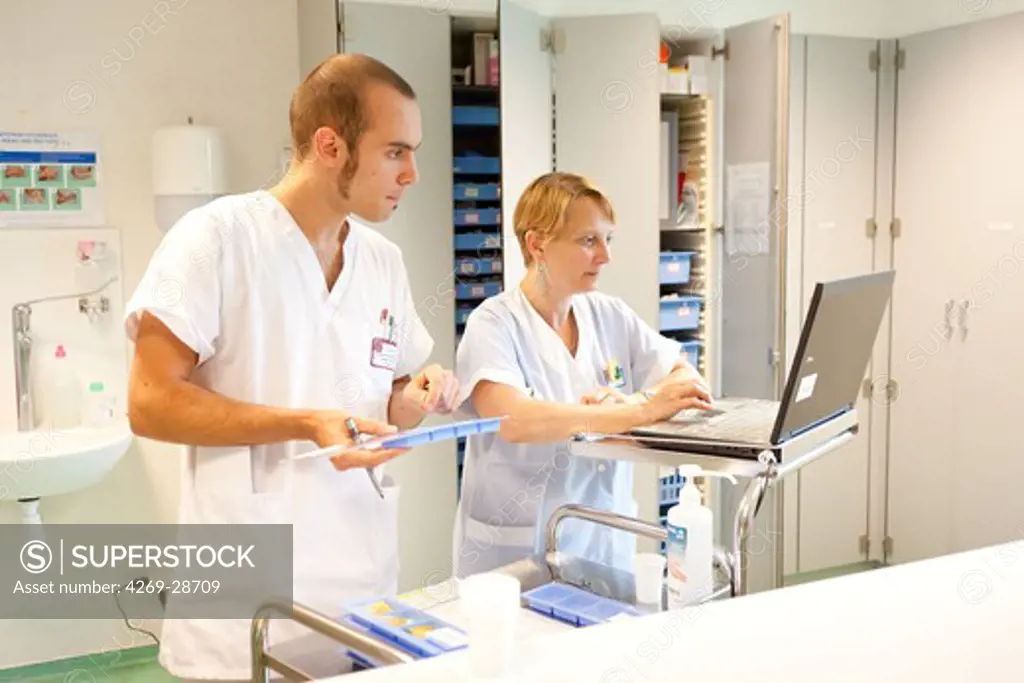 Nurse student and nurse preparing prescriptions. Bordeaux hospital, France.