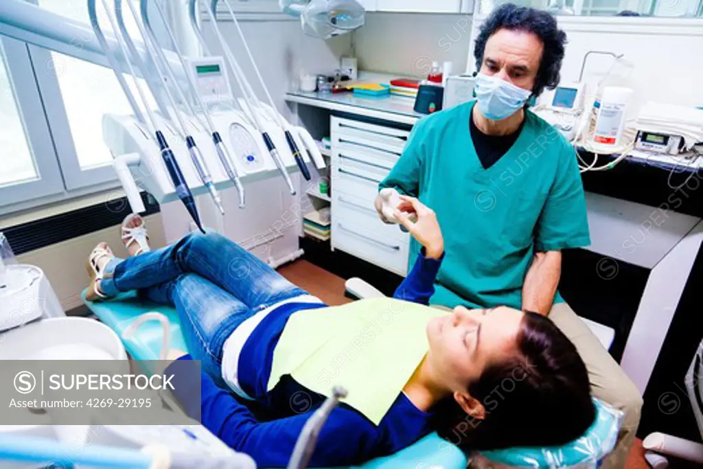 Woman undergoing ericksonian hypnosis at dentist. The hand in catalepsy indicates the stage of hypnotic transe.