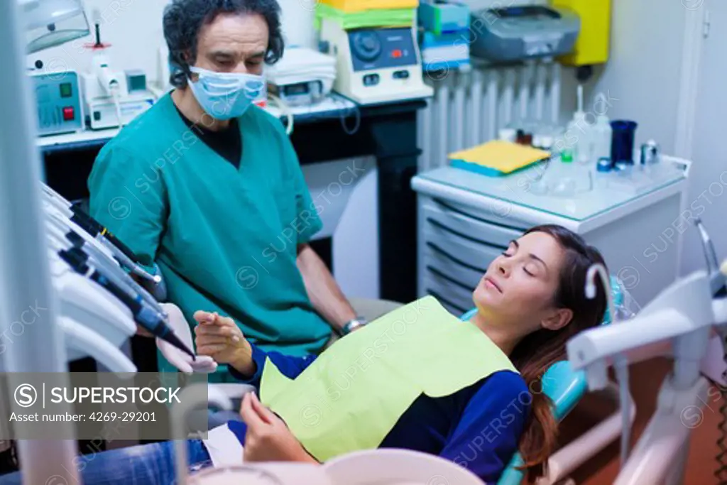 Woman undergoing ericksonian hypnosis at dentist. The hand in catalepsy indicates the stage of hypnotic transe.