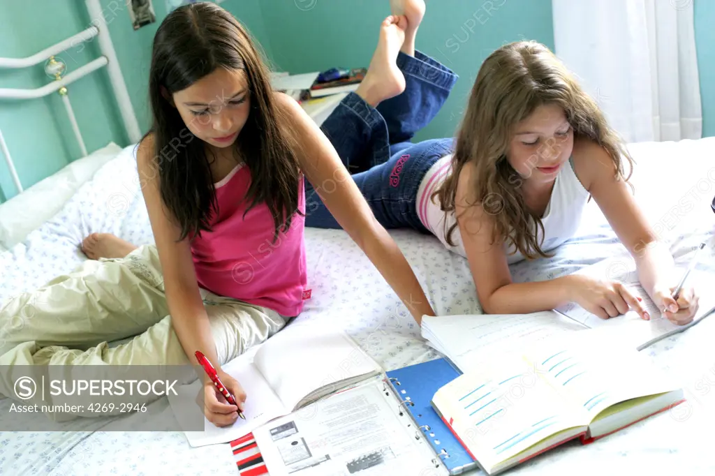 11 and 12 years old sisters doing their homework.