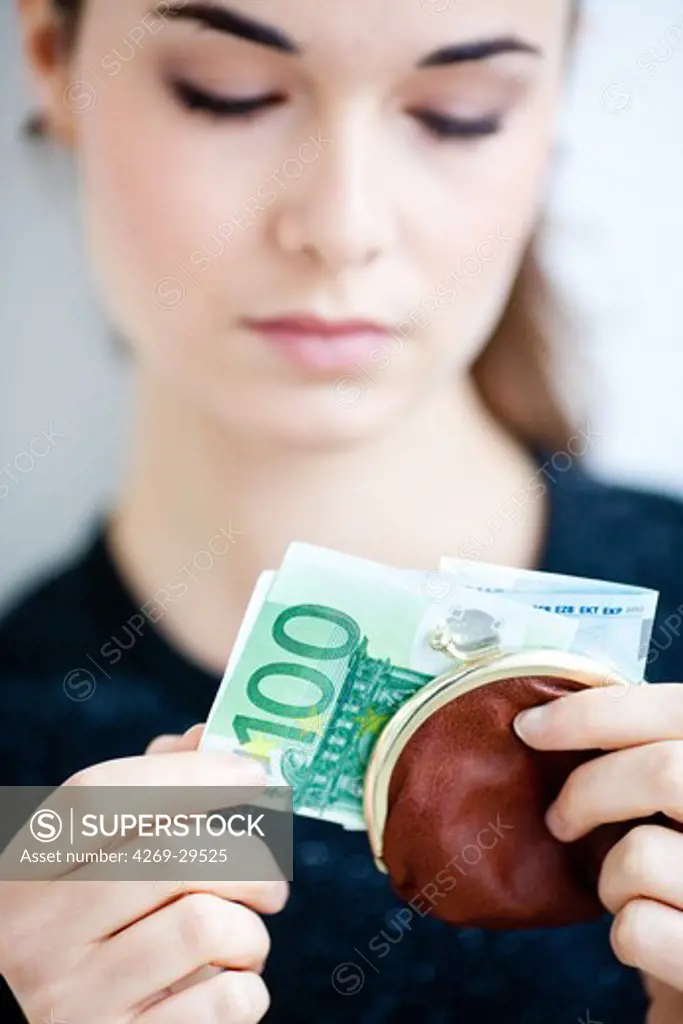 Woman holding purse with banknotes.