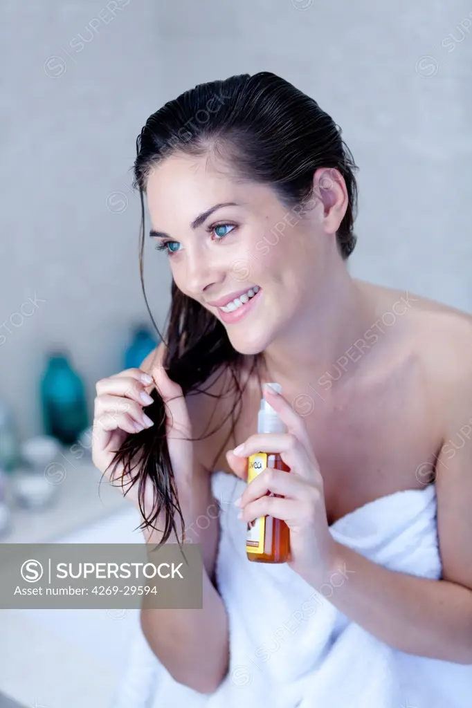 Woman applying oil on the tip of the hair.