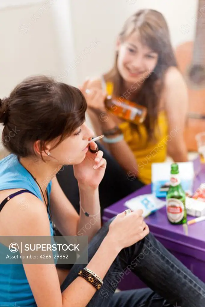 Teenagers smoking marijuana or hashish cigarette and drinking alcohol.