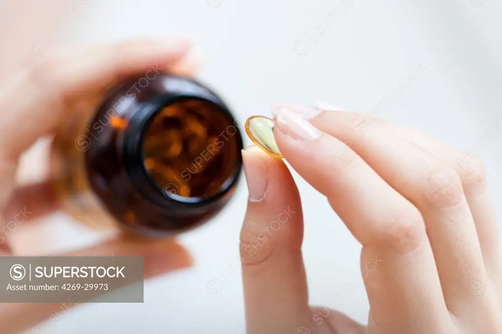 Woman taking food supplement capsules.
