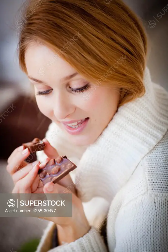 Woman. Woman eating hazelnut chocolate.