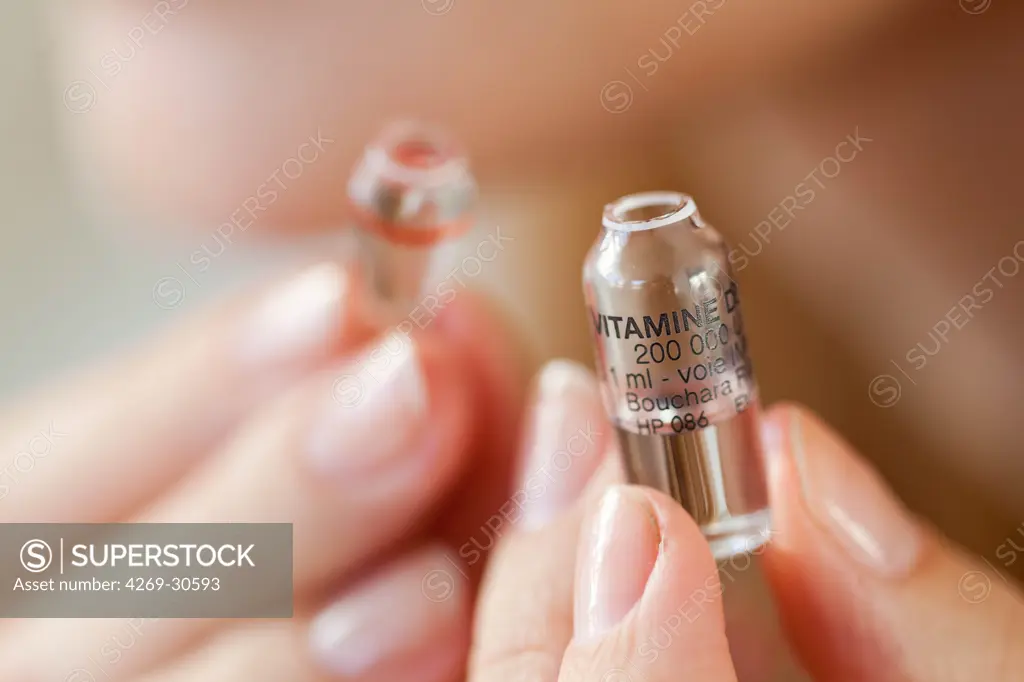 Woman. Woman holding glass ampoule of vitamin D.