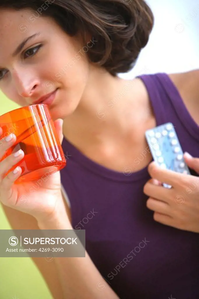 Young woman taking contraceptive pills.