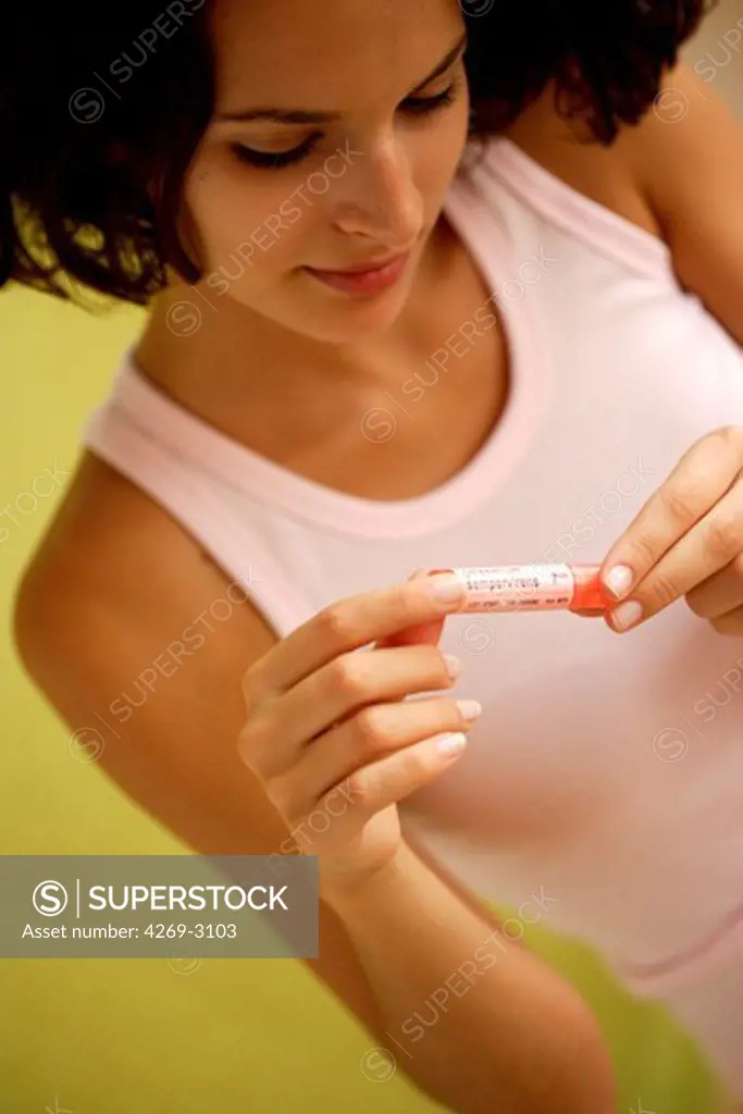Woman holding homeopathic medicine.