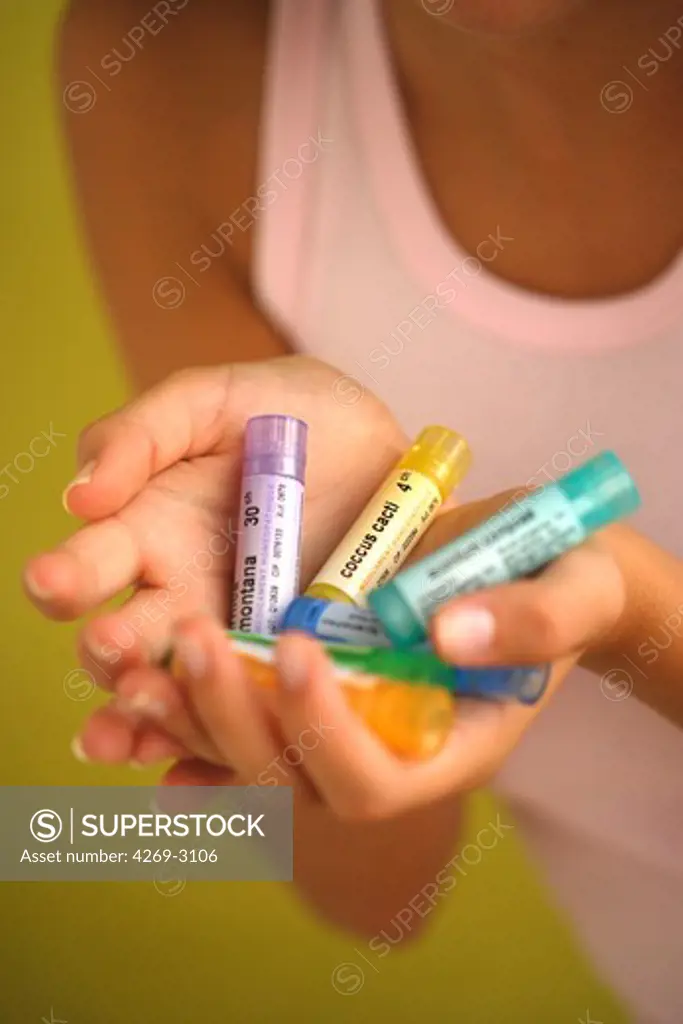 Woman holding homeopathic medicine.