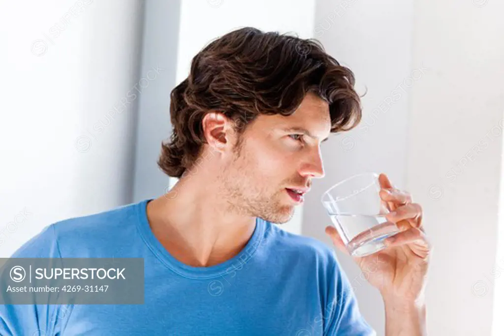 Man. Man drinking glass of water.