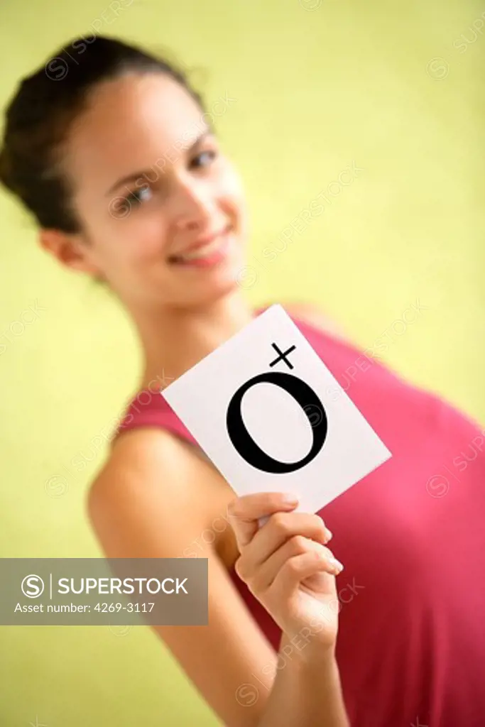 Woman holding a card of her blood group O, Rhesus (Rh) positif.