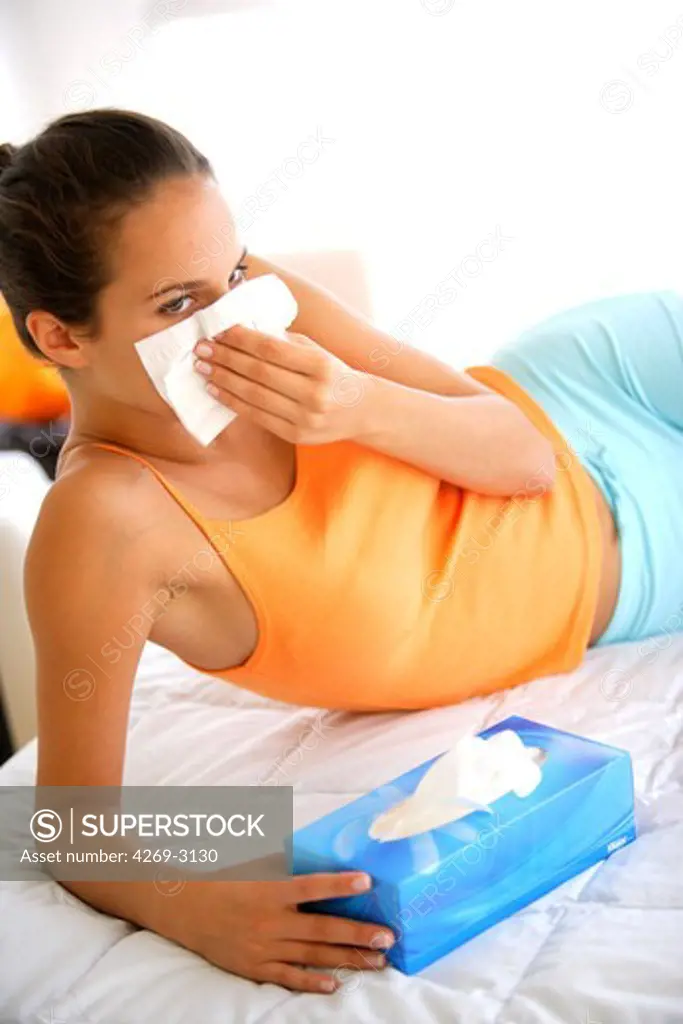 Woman blowing her nose with a tissue.