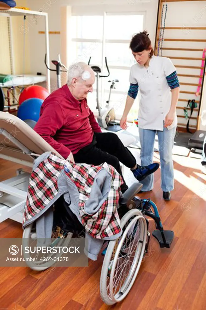 Old diabetic man who underwent a leg amputation in functional rehabilitation session with a physiotherapist.