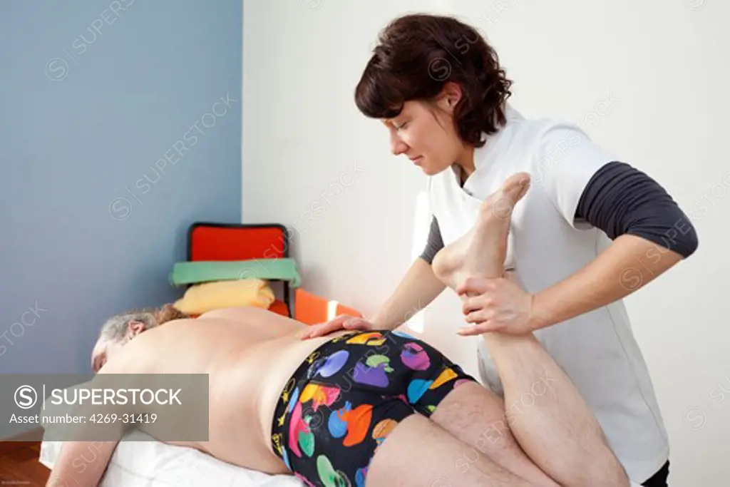 Physical Therapist practicing stretching and flexibility of a patient with back pain.