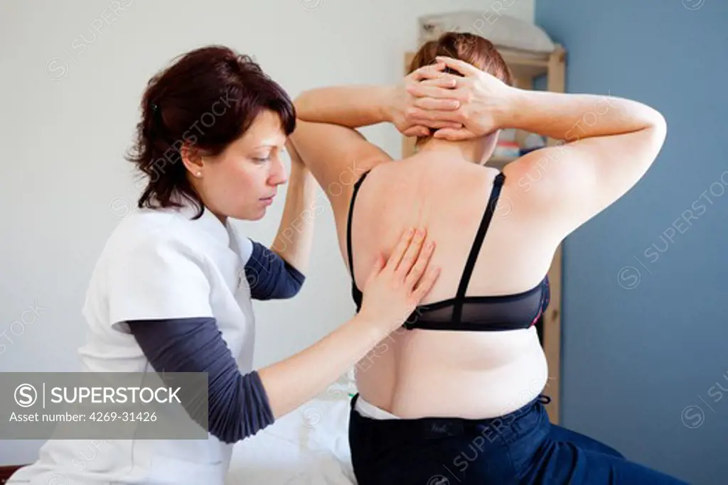 Woman suffering from neck pain receiving massage.