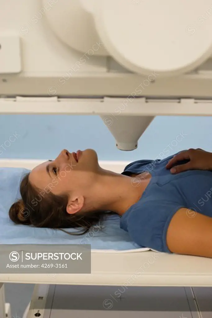 Young woman undergoing a gamma scan examination of the thyroid at the department of nuclear medicine, Angoulème Hospital, France.