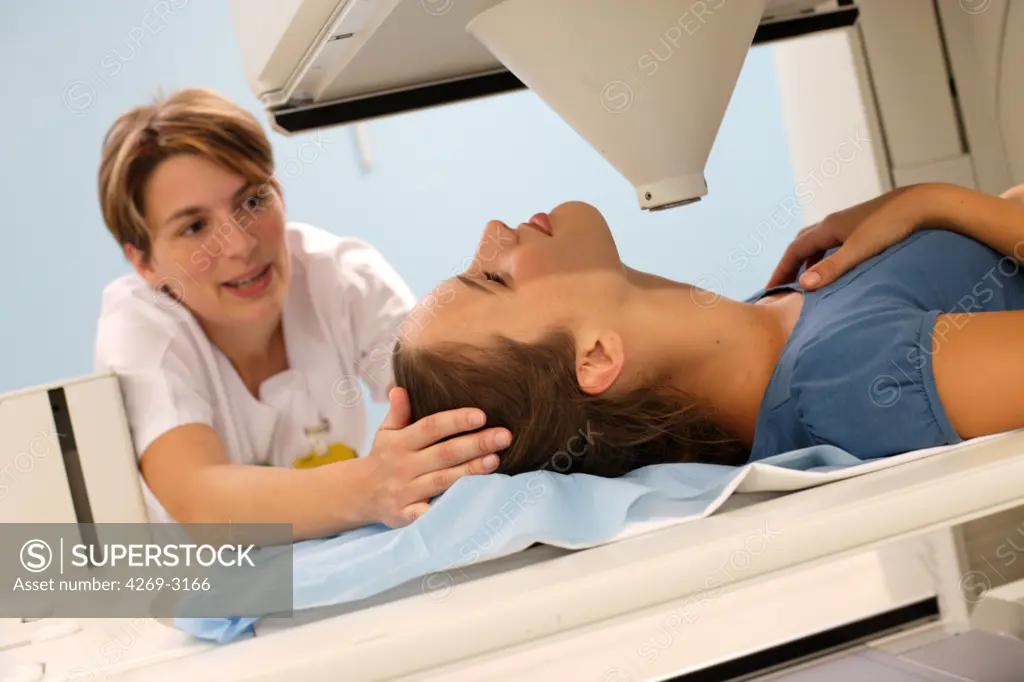 Young woman undergoing a gamma scan examination of the thyroid at the department of nuclear medicine, Angoulème Hospital, France.