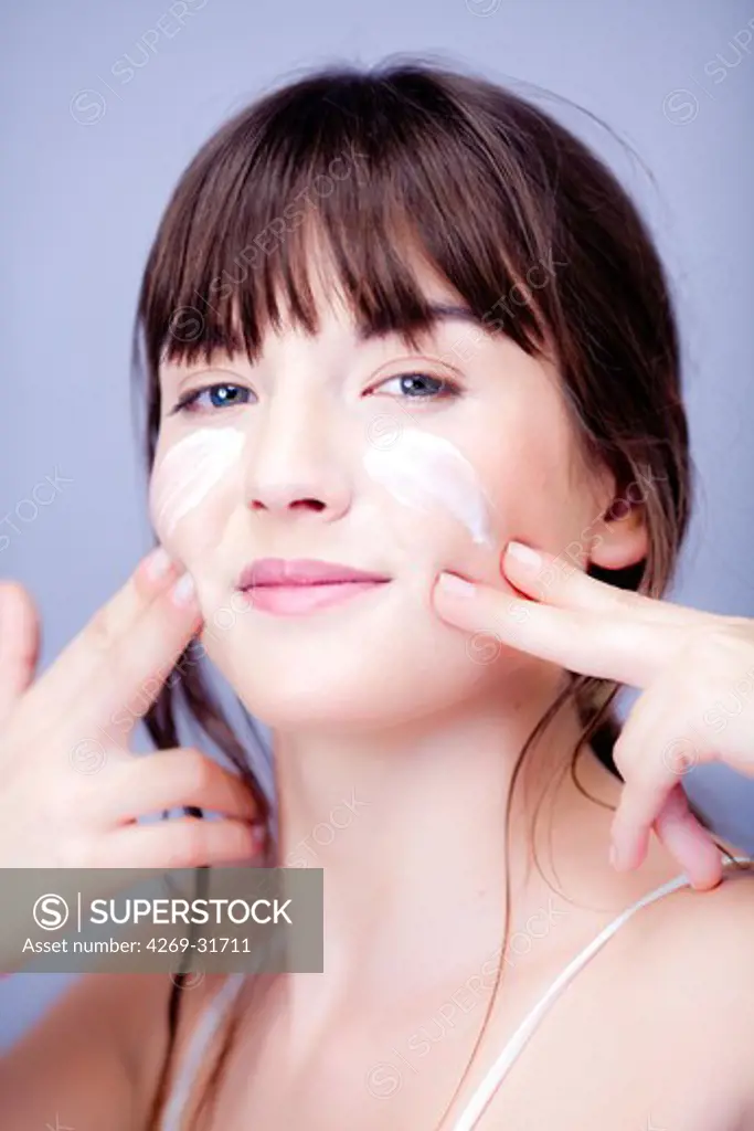 woman applying moisterizing cream.