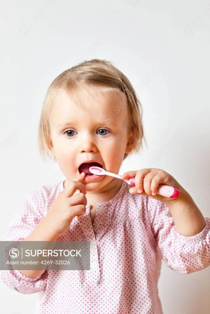 18 month old baby girl brushing her teeth.