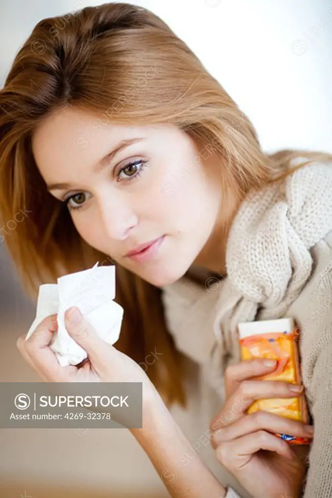woman with a cold using tissue.