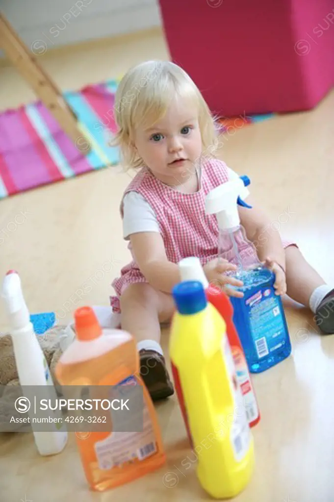 18 months old baby girl playing with house cleaning products : poisoning hazard.