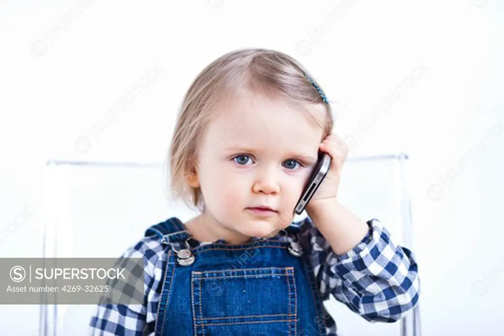 24 month old baby girl with cell phone.