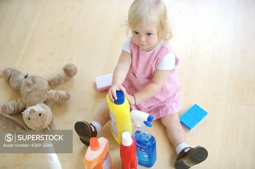 18 months old baby girl playing with house cleaning products : poisoning hazard.