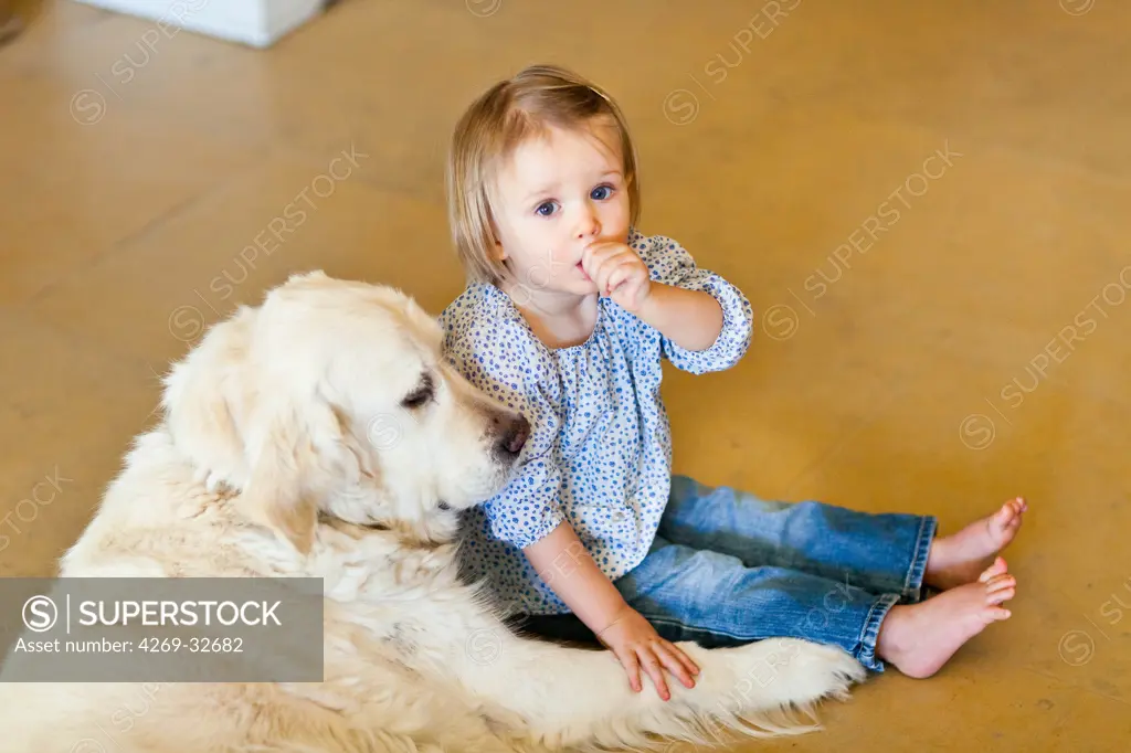 24 month old baby girl with a dog.
