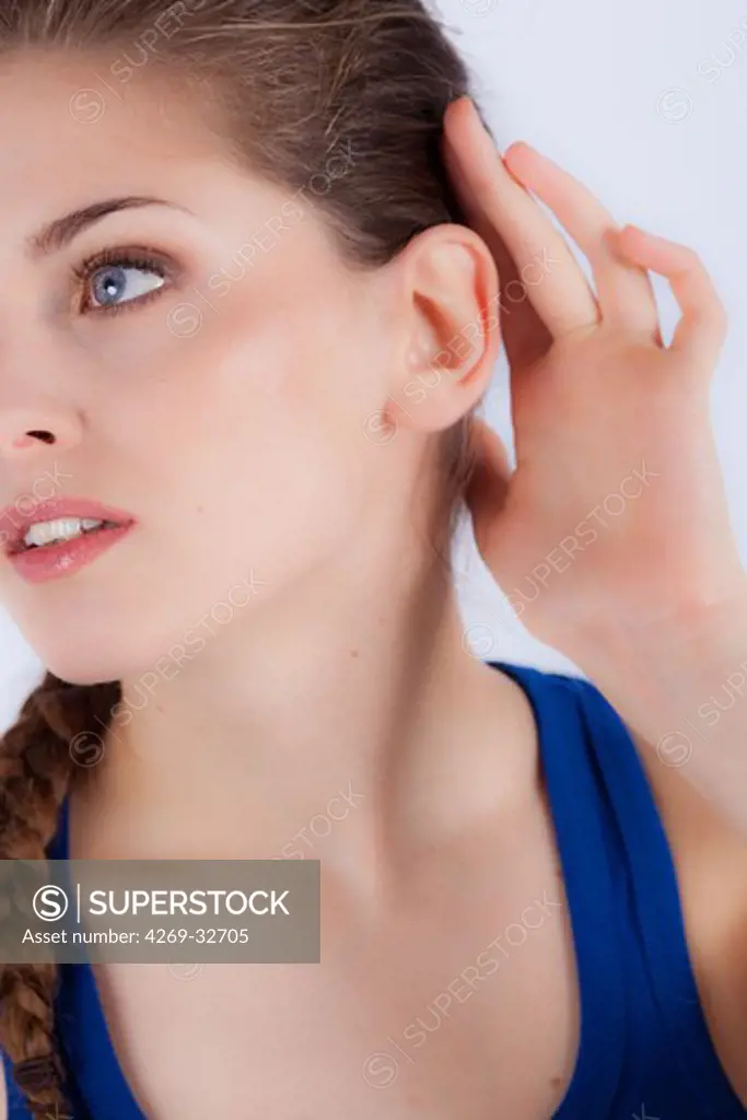 woman holds her hand to her painful ear.