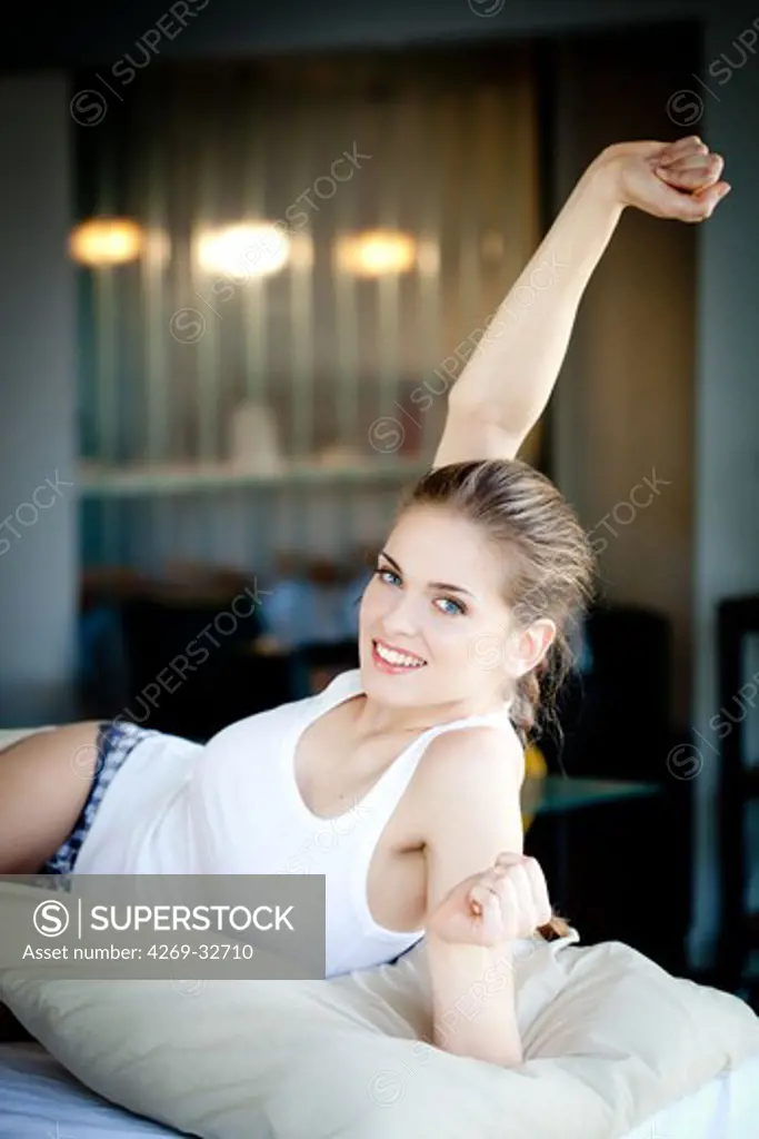 woman waking up and stretching in bed.