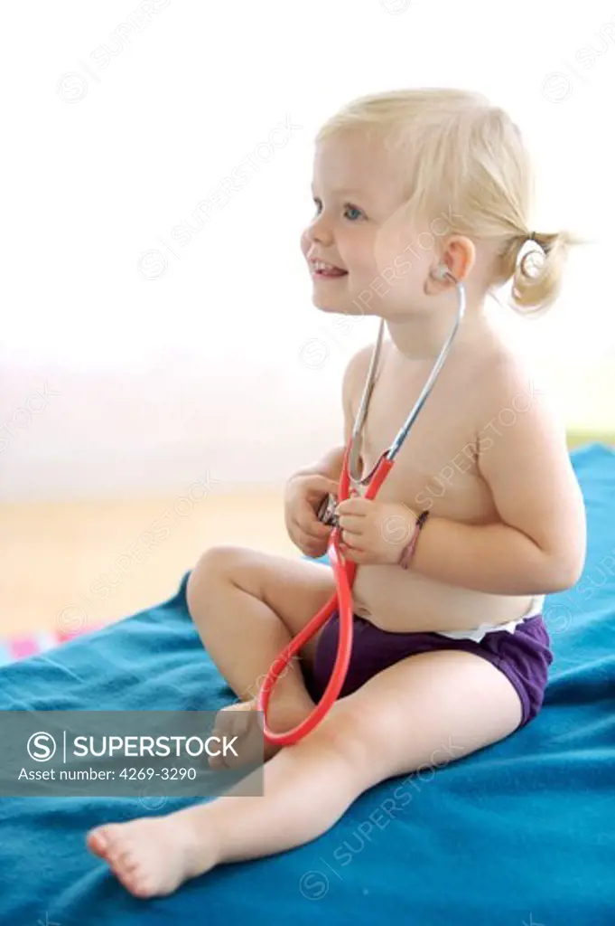 18 months old baby girl playing with stethoscope.