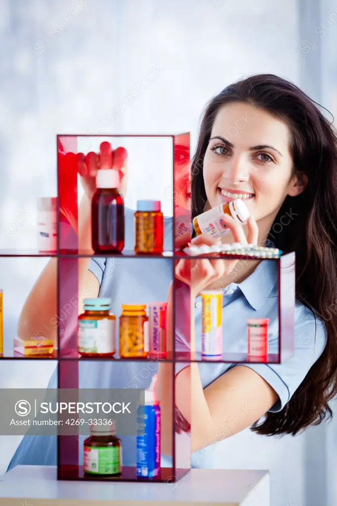 woman taking medication in a medicine cabinet.
