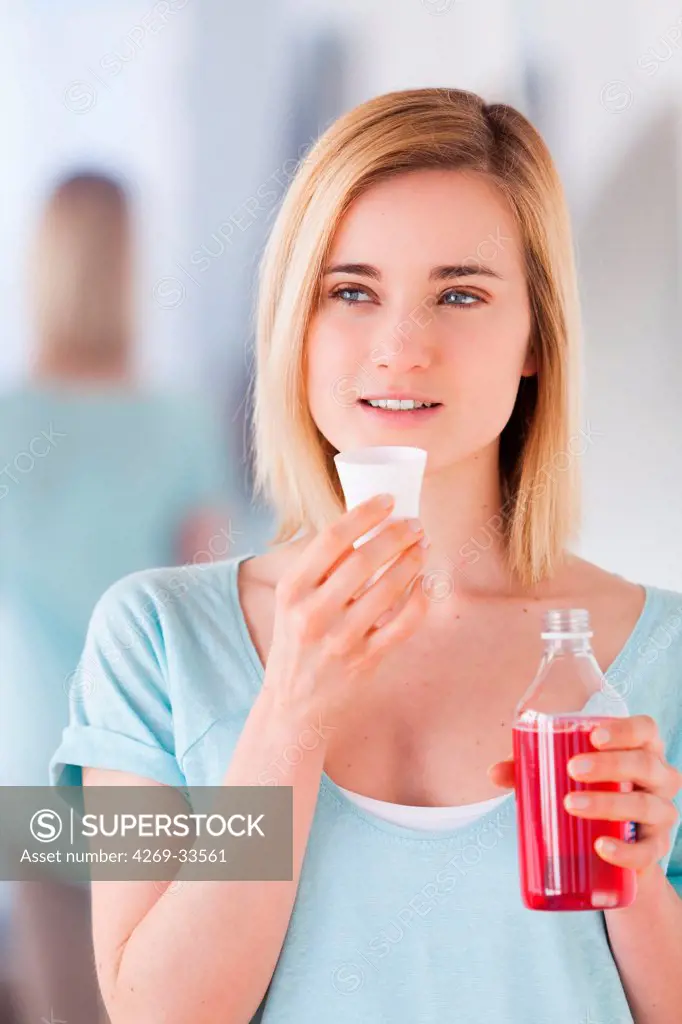 Woman using mouthwash.