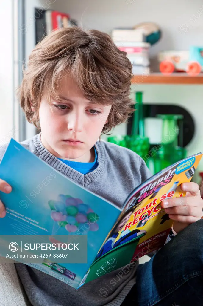 12 year old boy reading a news magazine.