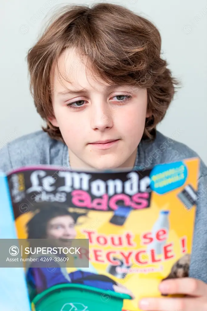 12 year old boy reading a news magazine.