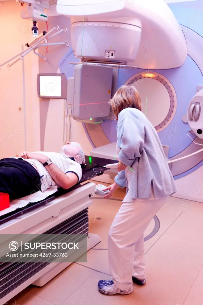 Radiotherapy radiographer with a male patient treated for a brain cancer with radiotherapy. Latest generation particle accelerator. Radiotherapy center pole of Oncology Hospital of Bordeaux. Hospital Haut-Leveque.