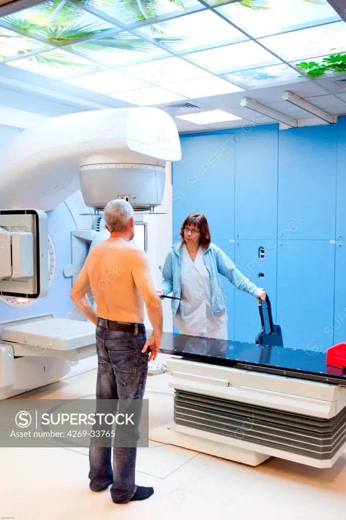 Radiotherapy radiographer with a male patient treated for a throat cancer with radiotherapy. Latest generation particle accelerator. Radiotherapy center pole of Oncology Hospital of Bordeaux. Hospital Haut-Leveque.
