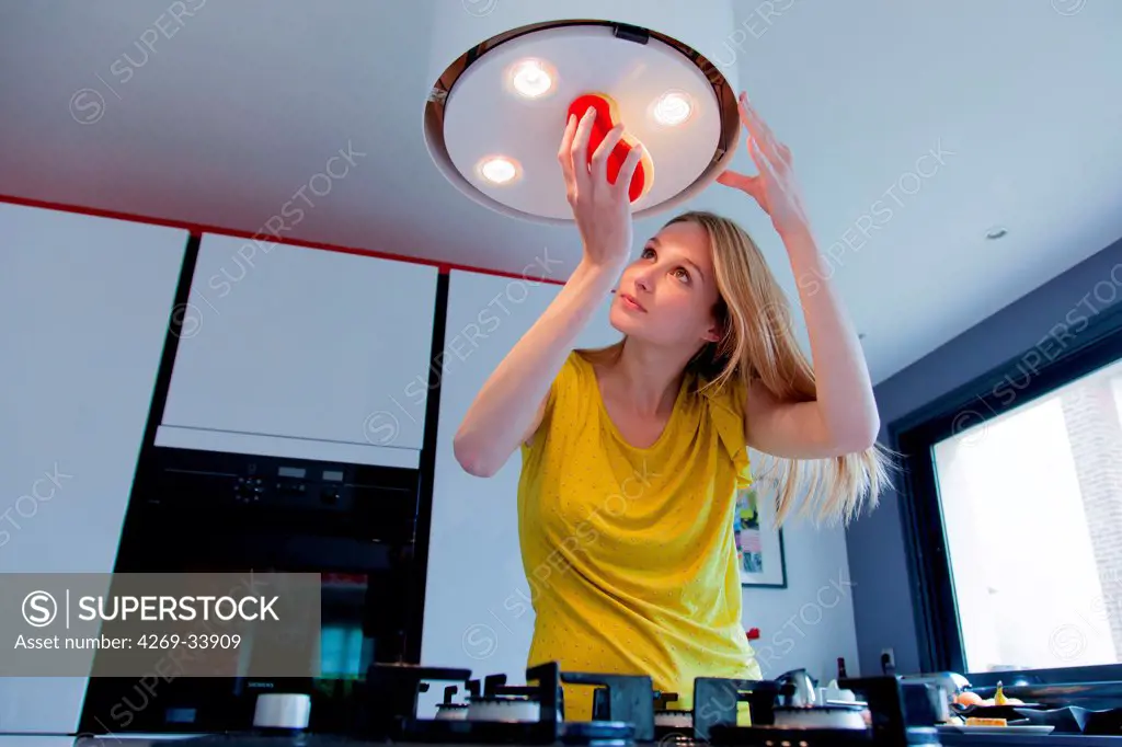 Woman cleaning a kitchen hood.
