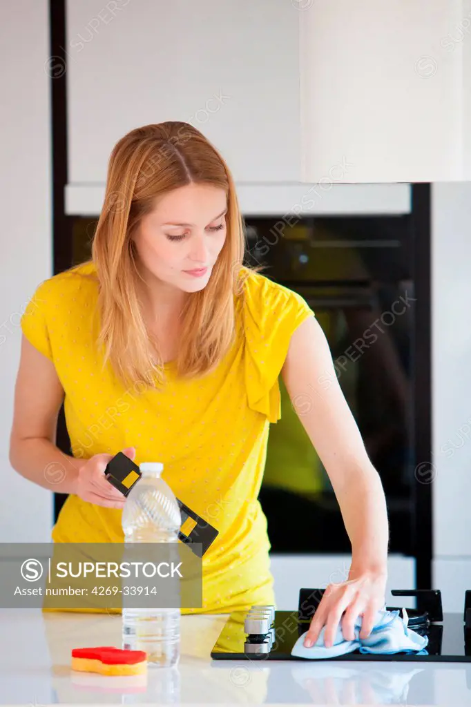 Woman using white vinegar to clean.