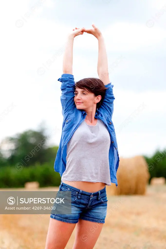 Woman stretching in a field.