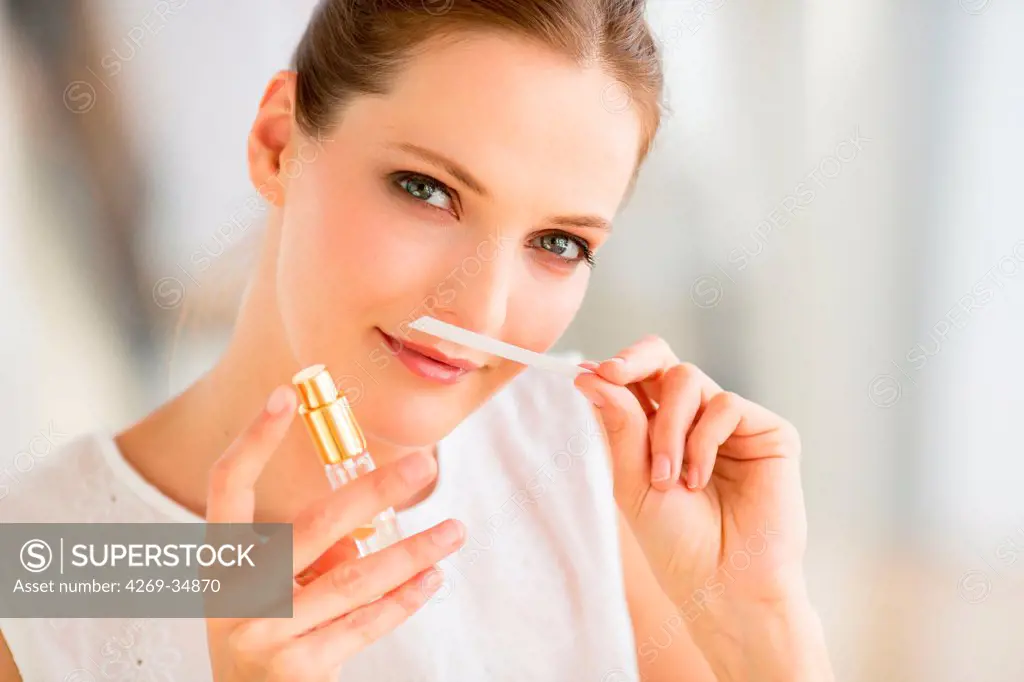 Woman smelling a perfume.