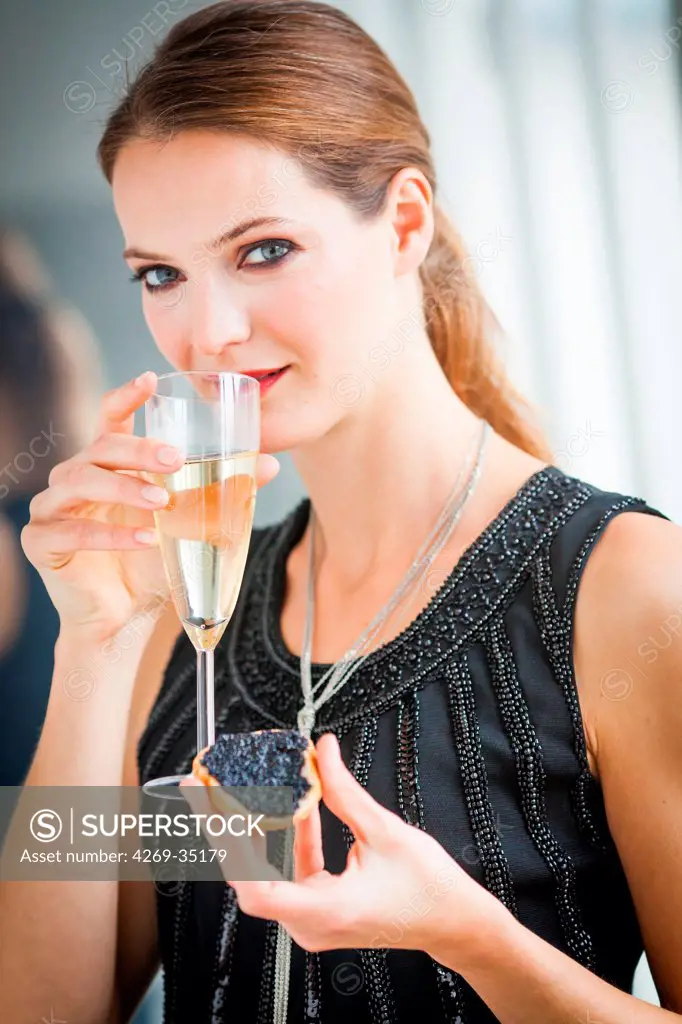 Woman drinking champagne and eating toast