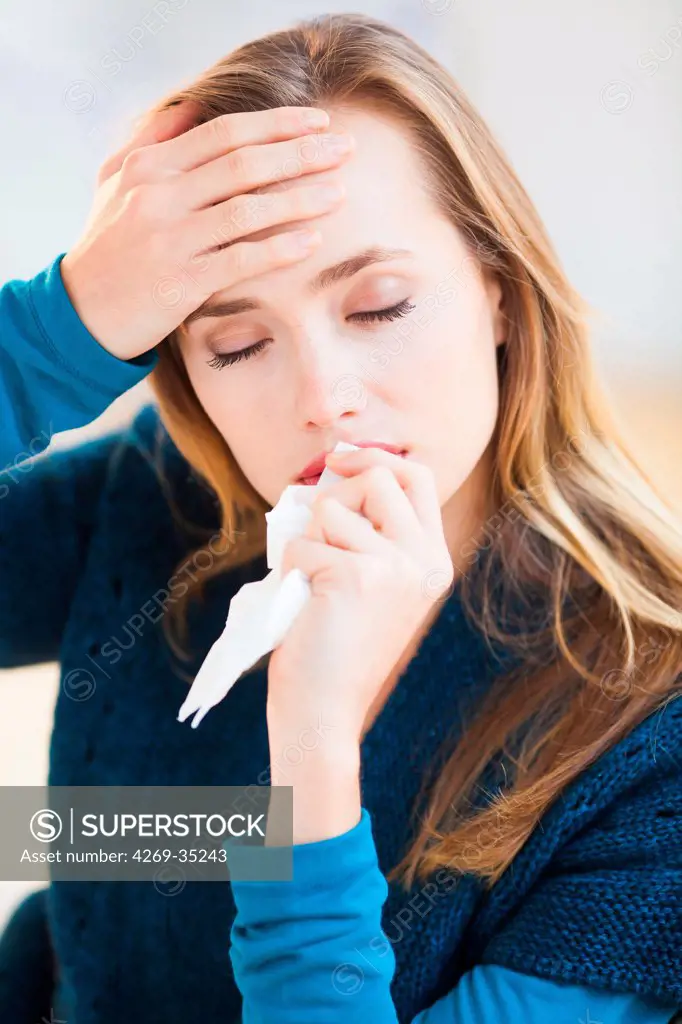 Woman with a cold using tissue