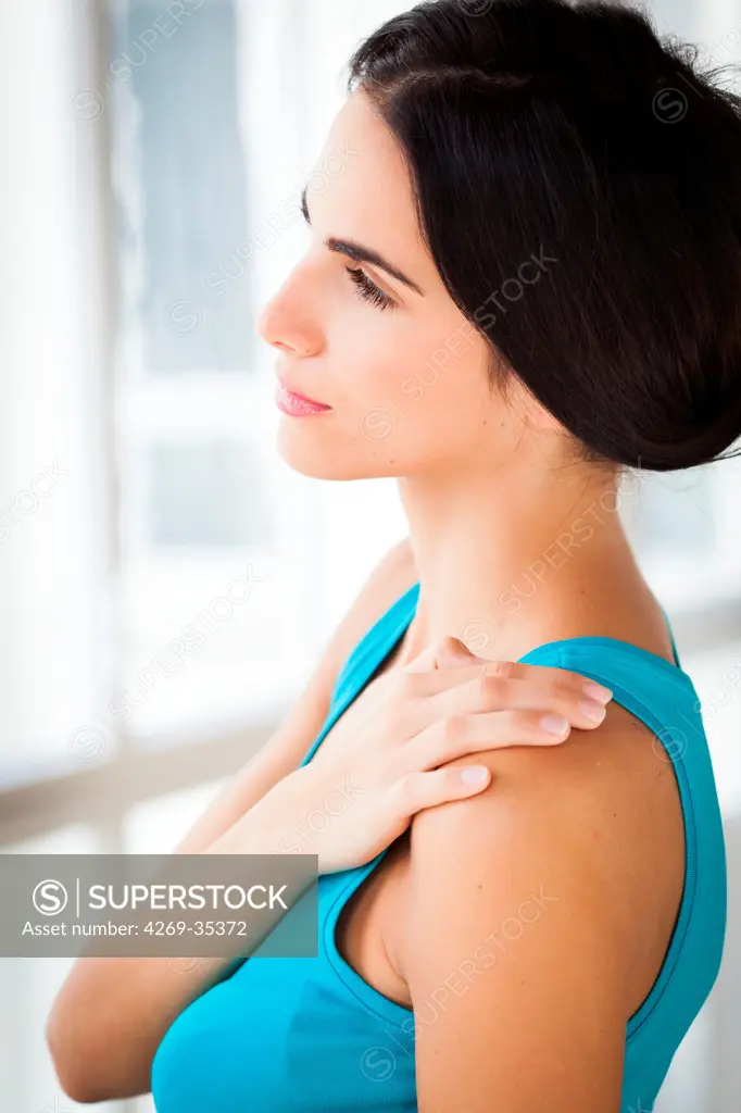 Shoulder pain Woman rubbing her shoulder