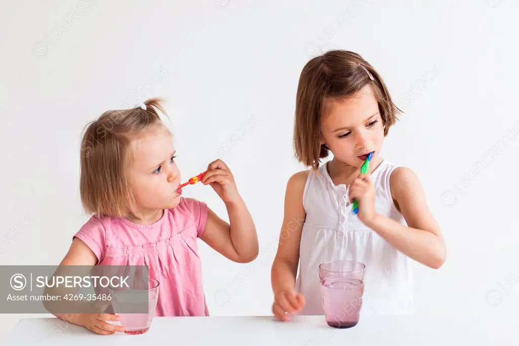 2 and 5 year old girls brushing their teeth