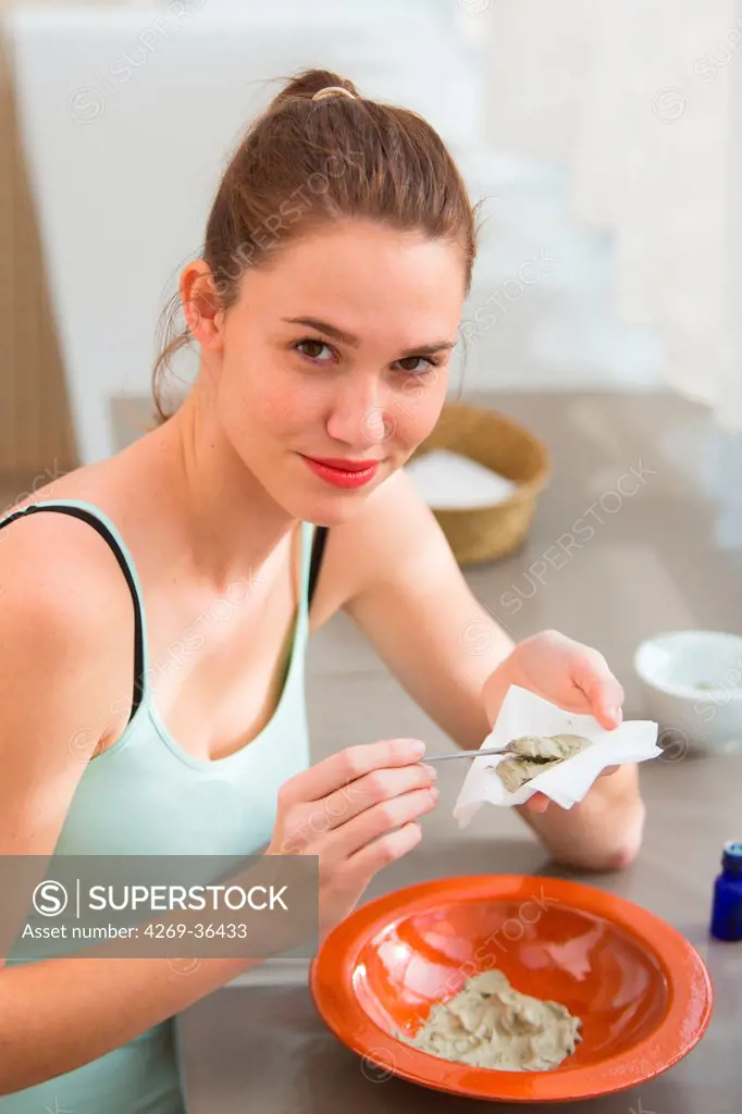 Woman preparing a poultice with green clay