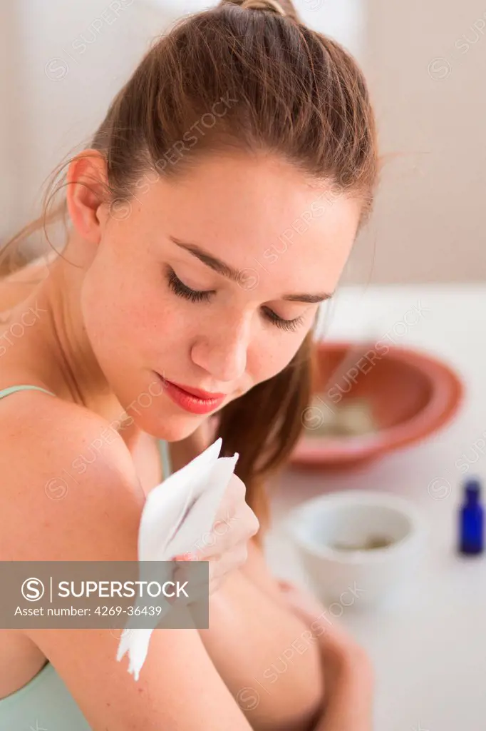 Woman applying a poultice on her shoulder