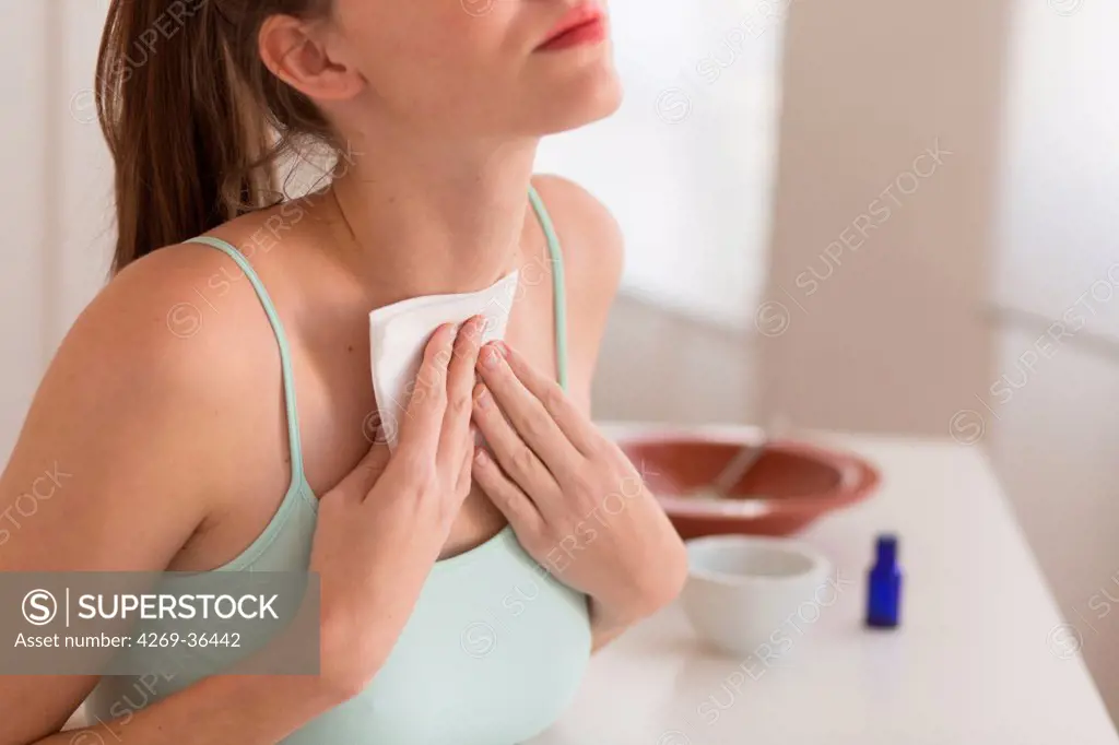 Woman applying a poultice on the thyroid